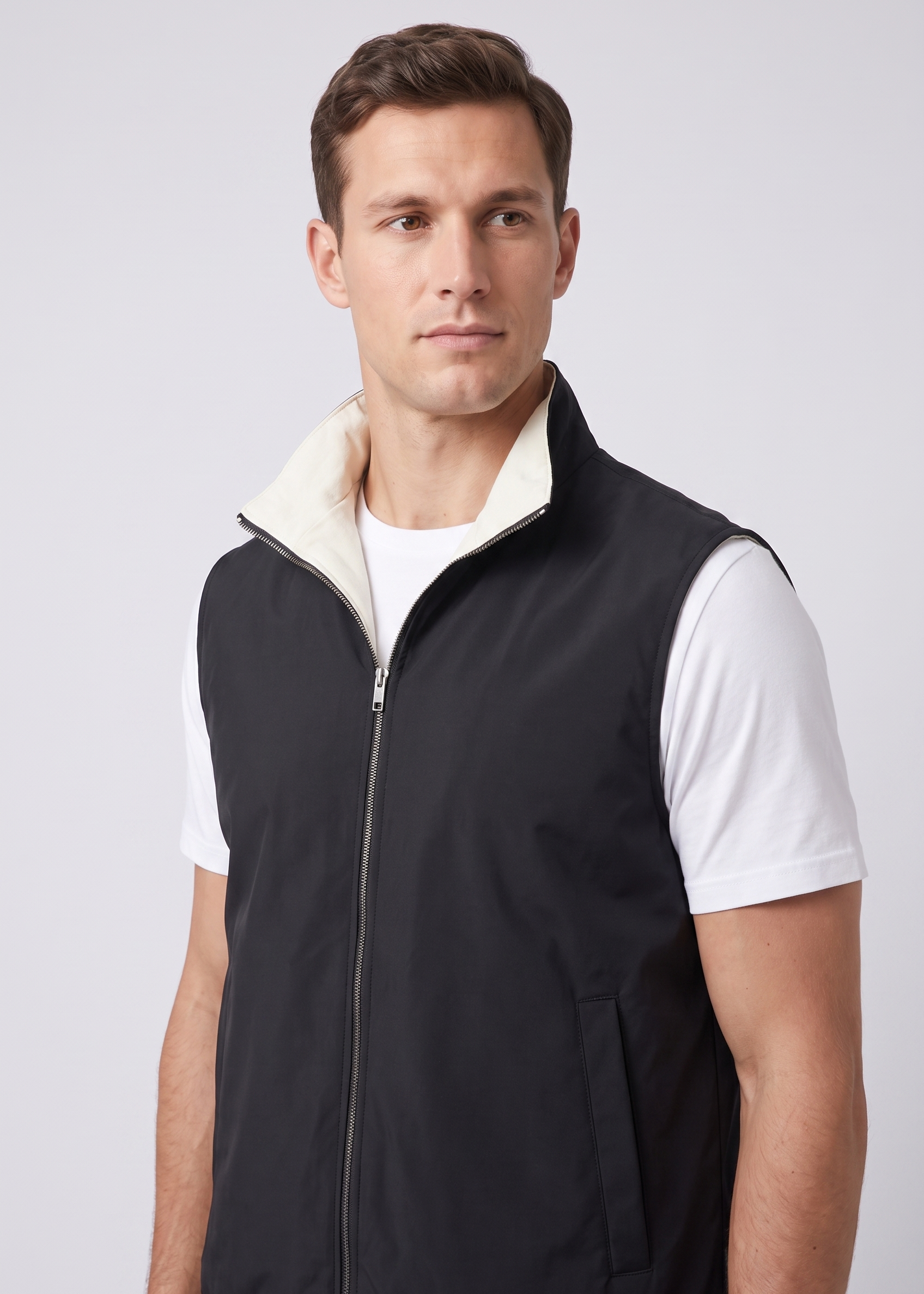 Detail du gilet reversible MONVALERE : col montant a doublure ecru, zip argente et poche passepoilee, vue trois-quarts