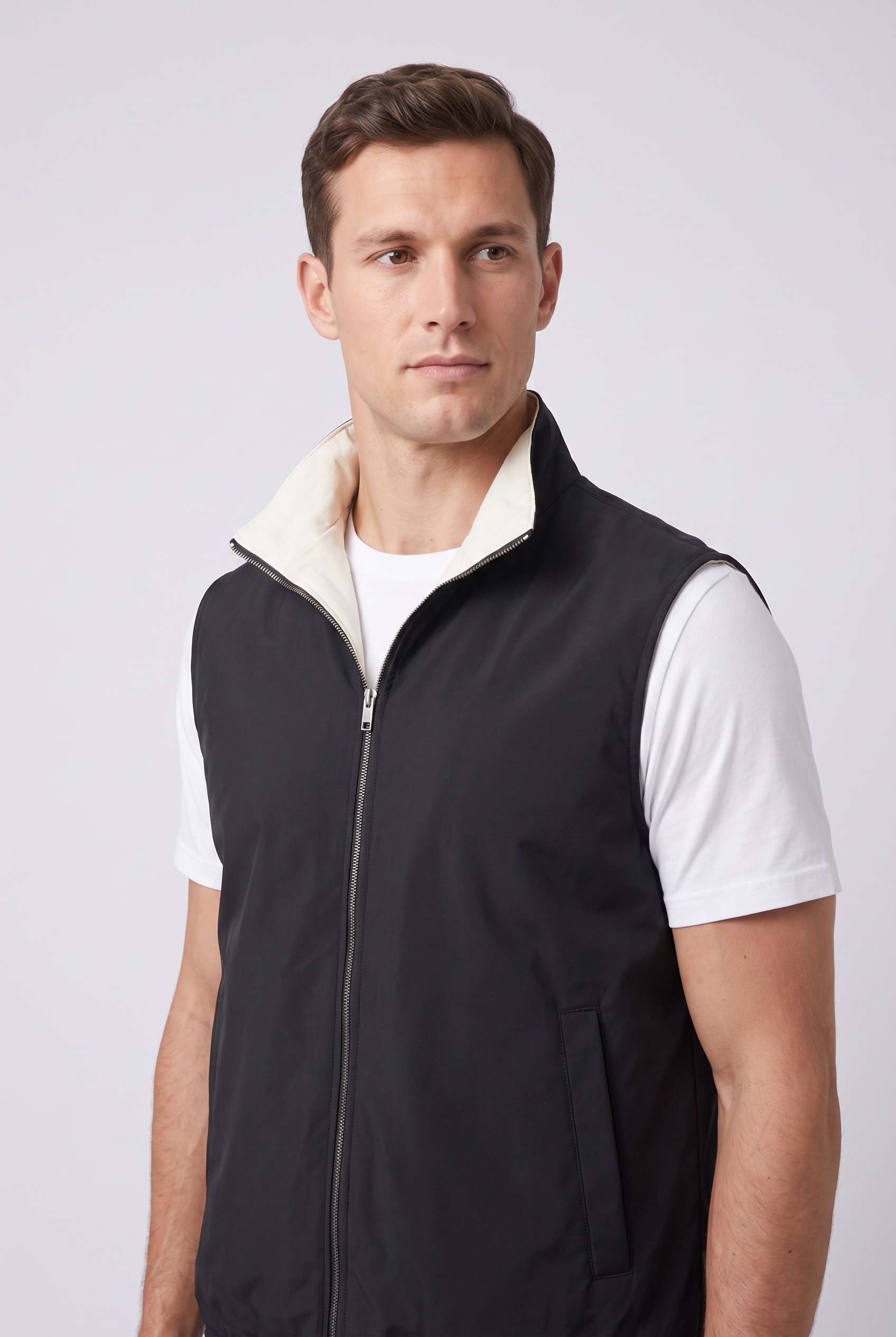 Detail du gilet reversible MONVALERE : col montant a doublure ecru, zip argente et poche passepoilee, vue trois-quarts
