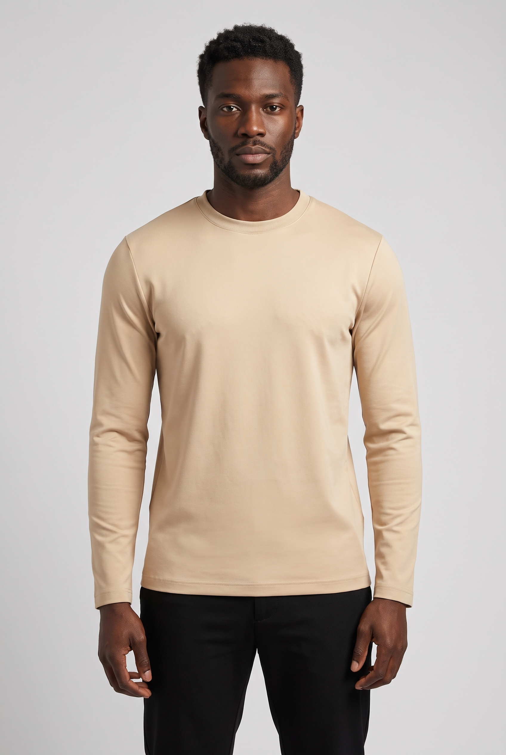 Homme portant le t-shirt manches longues beige MONVALERE, vue de face, cadrage mi-cuisse, fond studio gris clair